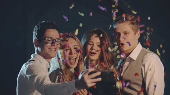 Smiling Multiracial Friends Throw Confetti Posing and Taking Selfie on Smartphone or Mobile Phone