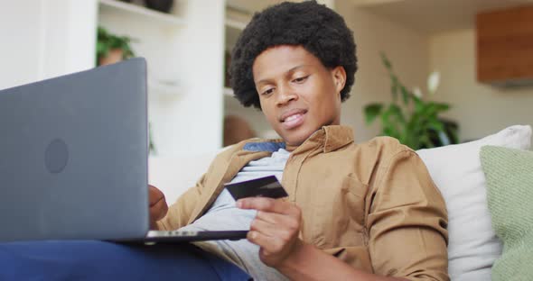 African american man using laptop at home