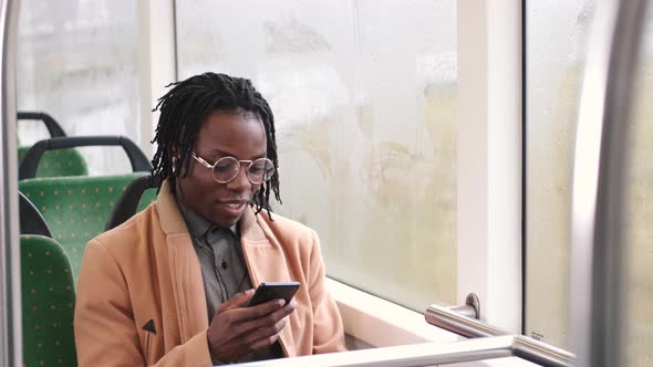 African American Guy in Cadual Clothes Use Phone in Public Transport