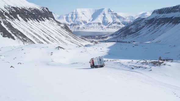 Passenger winter mountain tracked vehicle leaving after transporting hikers, handheld