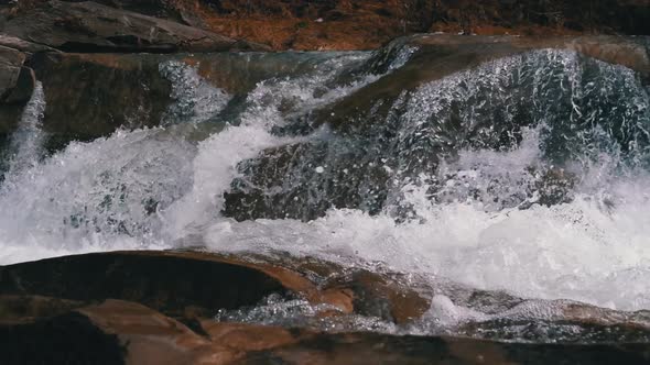 Mountain Creek and Stone Rapids with Snow. Rapid Flow of Water. Waterfall in the Winter. Slow Motion