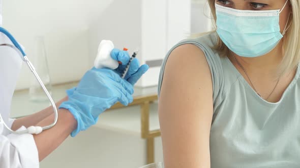 Nurse Vaccinates Female Patient in Clinic