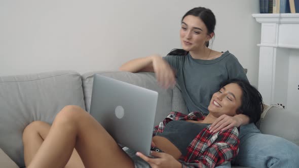 Two Happy Young Women Waving Hand Having Virtual Video Chat on Laptop at Home