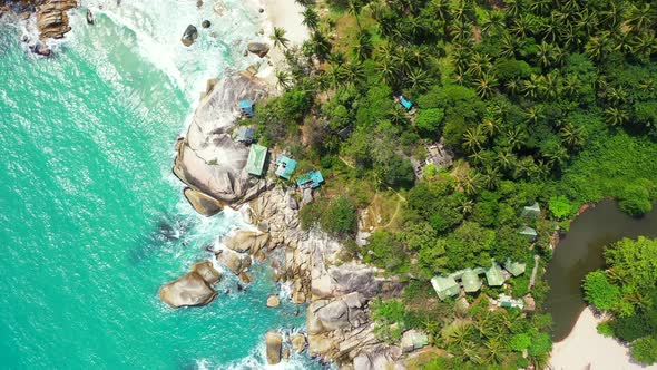 Colorful houses on the rocky forested shore between two sandy beaches, Haad Thong Reng and Haad Than