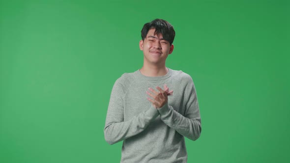 An Asian Man Clapping Her Hands In The Green Screen Studio