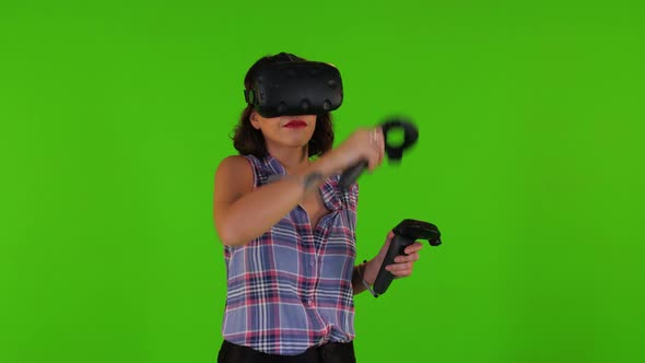 Playing Happily in A Vr by A Young Woman Over a Green Screen, Using Remotes, Casual Look