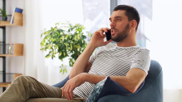 Smiling Man Calling on Smartphone at Home