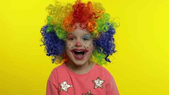 Little Child Girl Clown in Colorful Wig Making Silly Faces. Having Fun, Smiling, Laughing. Halloween