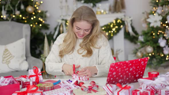 Happy Young Woman Having Video Chat on Laptop in Christmas Decorated Living Room