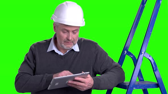 Man in Hard Hat Using Digital Tablet.