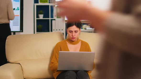 Concentrated Manager Reading Mails Typing on Laptop Sitting on Couch