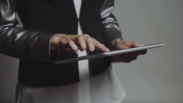 Business woman with tablet. Young pretty business woman taping on tablet in studio