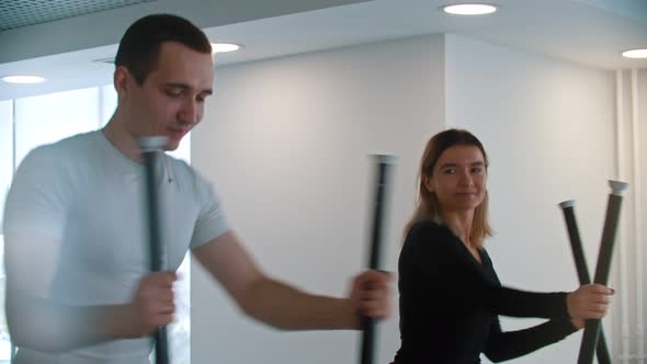 Modern Gym - a Guy in White T-shirt and a Woman Doing Morning Exercises in the Gym and Laughing