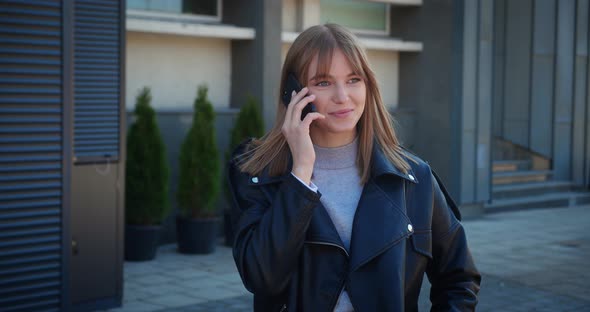 Young Blonde Woman Talking By Mobile Phone Outdoors on the Street