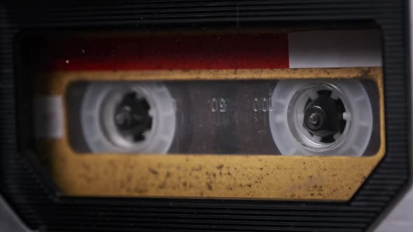 Vintage Yellow Audio Cassette Tape Rotates in Deck of an Old Tape Recorder