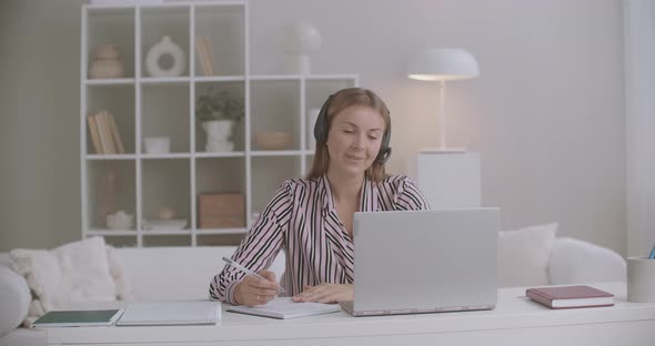 Female Specialist of Call-center or Tech Support Is Answering on Call of Client From Home, Working