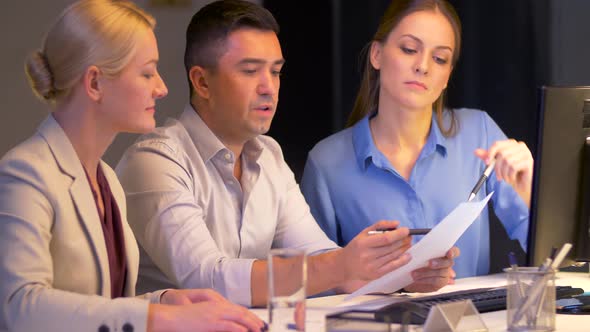 Business Team with Papers Working at Night Office 