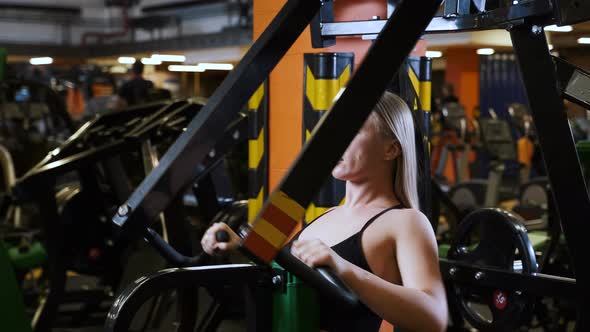 Woman doing exercise pulling the trainer in gym. Working hard on workout