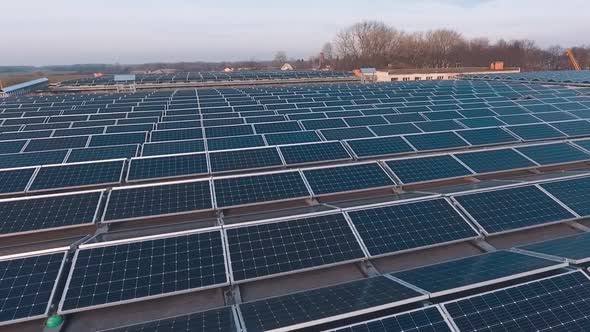 Flight over the modern photovoltaic panels on a roof. Innovative solar power station with blue sunny