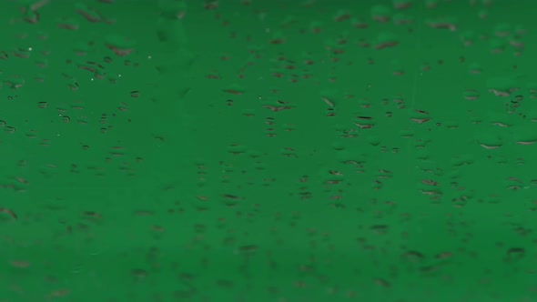 Raindrops on glass. Green screen background.