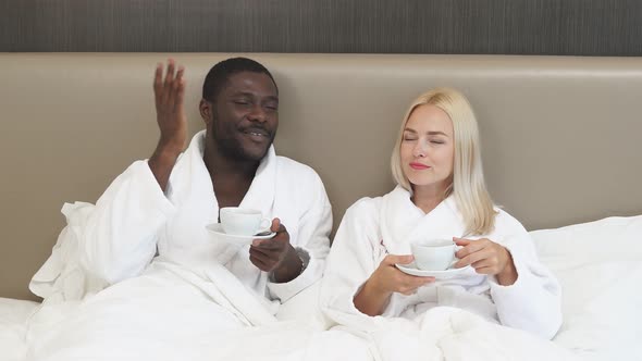 Portrait of Beautiful Multiethnic Couple Drinking Tea on Bed