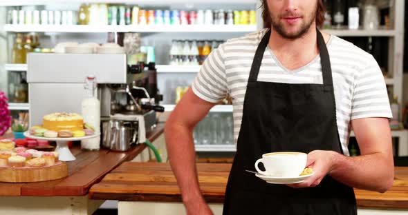 Male waiter holding a cup of coffee