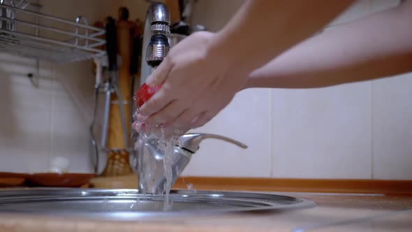 Female Hands Washing a Ripe Red Apple with Running Water From the Tap