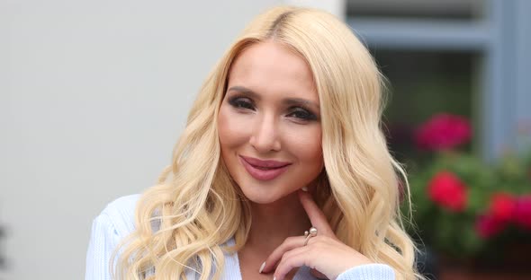 Portrait of Adorable Young European Blonde Woman with Makeup Smiling Posing Looking at Camera