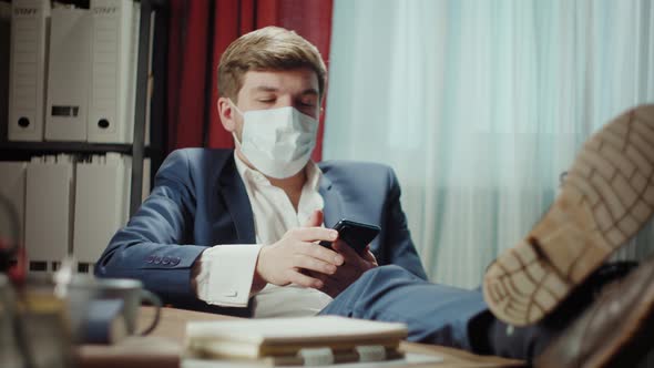 Portrait of Handsome Mature Businessman in Medical Mask Working on Phone Speaking with Confident