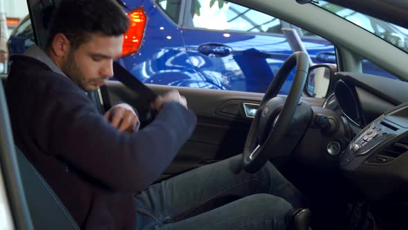 Man Fastens His Seat Belt in the Car