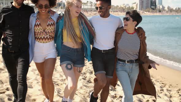 Happy Diverse Friends Walking on Beach in Embrace