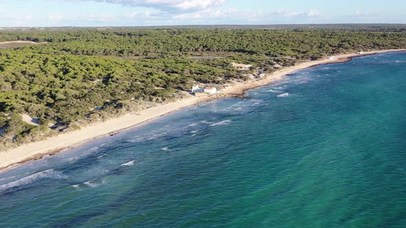 Trenc Beach in Mallorca Spain with a concrete building foundation pounded by waves, Aerial approach