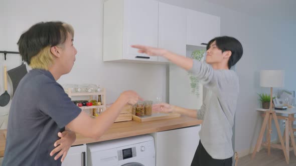 Asian happy handsome man gay couple sing and dance together in kitchen.