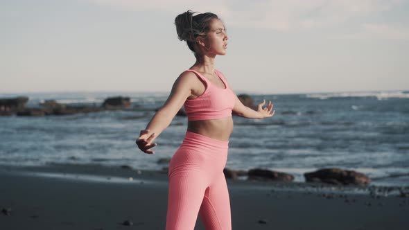 Side View of Beautiful Young Woman Doing Squats at the Seashore