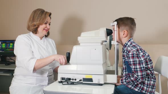 Ophthalmologist Treatment - Mature Smiling Woman Cheking Boy's Eyes