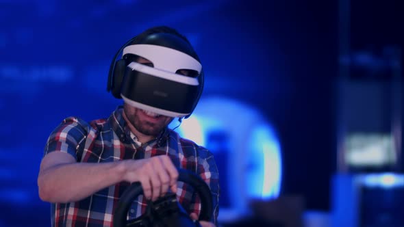 Happy and Excited Man Playing Racing Video Game with Virtual Reality Headset