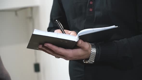 Professional Journalist Interviewing and Writing Text To Notebook. Man Keep Diary. Unrecognizable