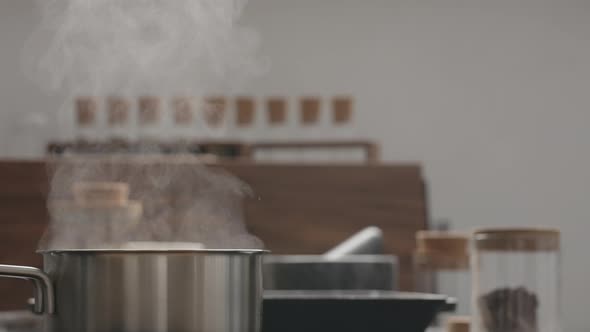 Slow Motion Orbit Shot of Steam Rising From Saucepan on Kitchen