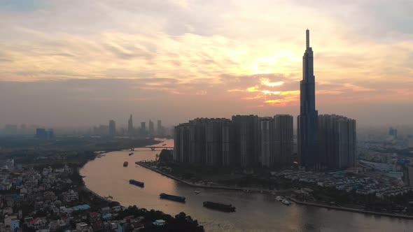 Aerial of boats on Saigon river and distinctive Landmark 81; sunset cityscape