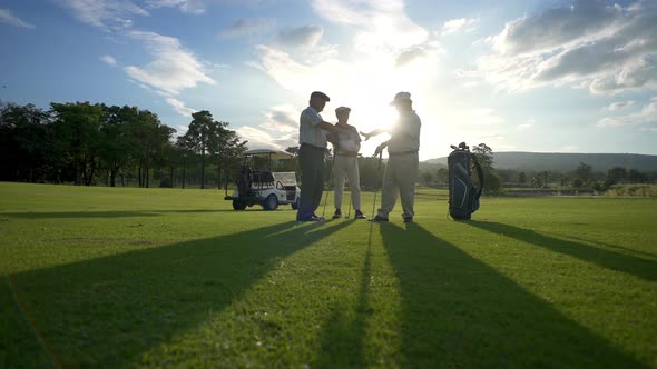 4K Group of Asian men golfer shaking hand after finish the game on golf course at summer sunset