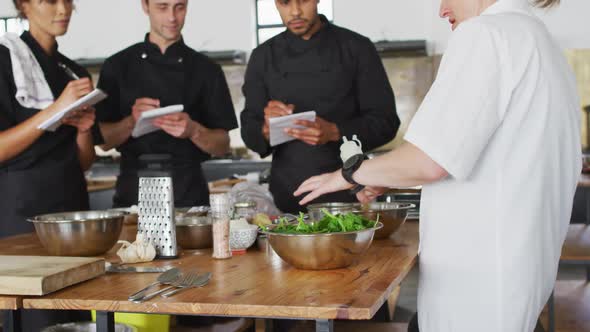 Caucasian female chef teaching diverse group