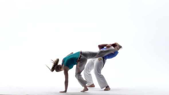 Woman and Man Are Practicing Capoeira in White Background of Studio. Afro-Brazilian Martial Art That