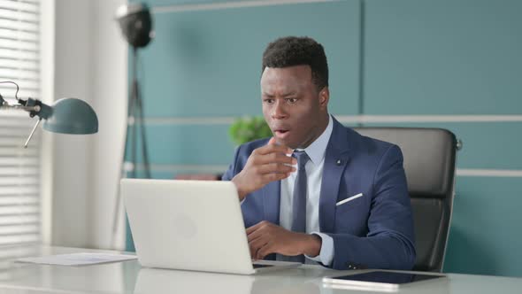 African Businessman Feeling Shocked While Using Laptop in Office