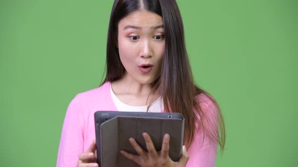 Young Beautiful Asian Woman Using Digital Tablet