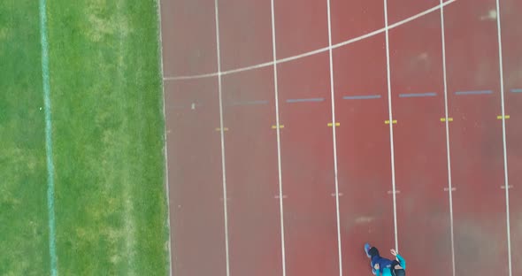 Cinematic Shot of Young Arab Sportswoman with Athletic Body in Hijab Running with Effort and