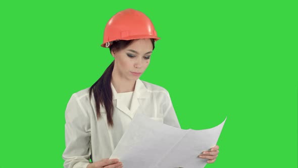 Young Female Architect Holding Blueprints and Checking Construction on a Green Screen, Chroma Key