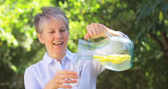 Senior woman pouring lemonade from a jug