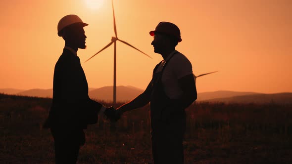 Silhouette of African American Engineer and Indian Inspector Using Digital