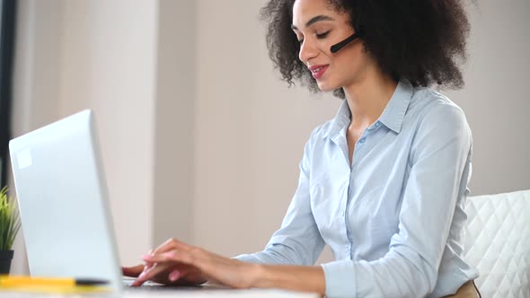 A Young Biracial Woman Is Using a Laptop Indoor