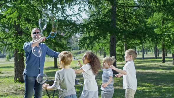 Man Performing Tricks with Soap Bubbles for Children alt